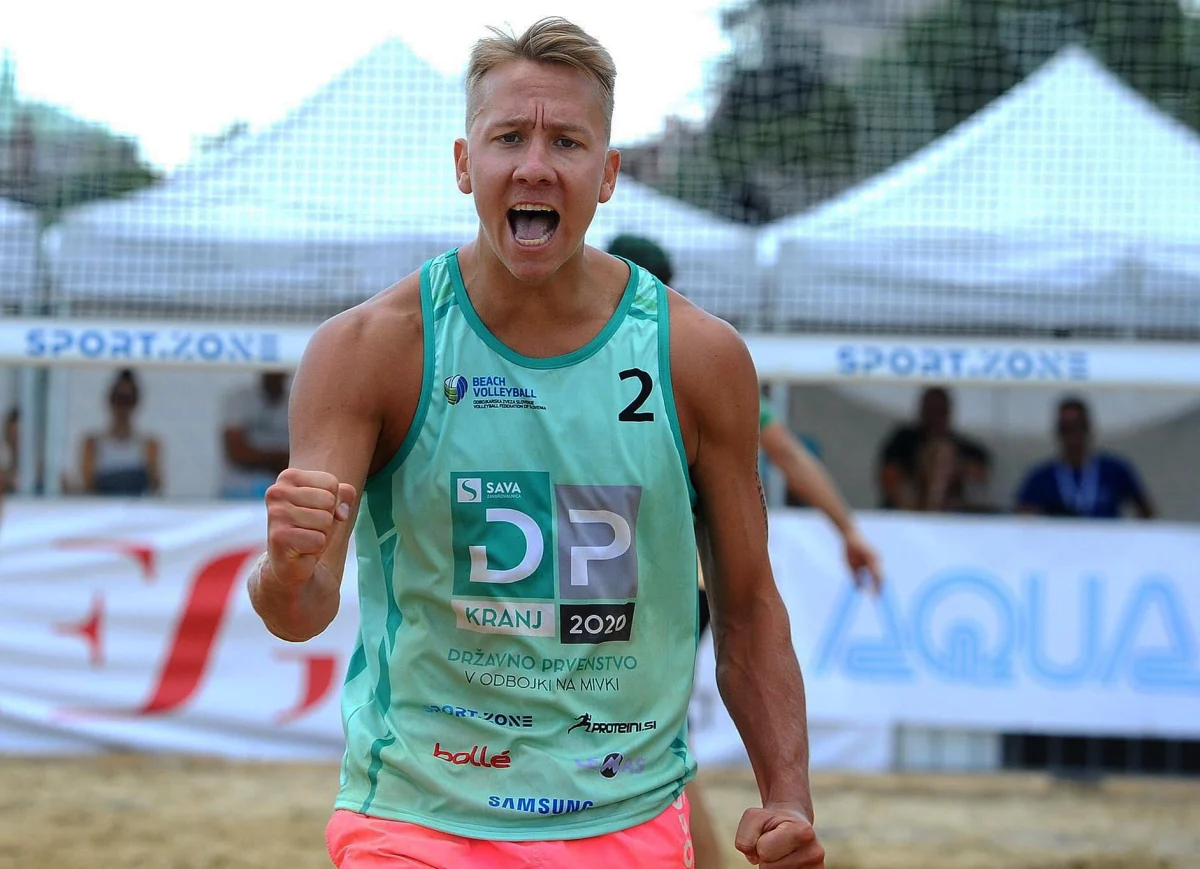 Alan Košenina celebrating a point in a turquoise beach volleyball jersey