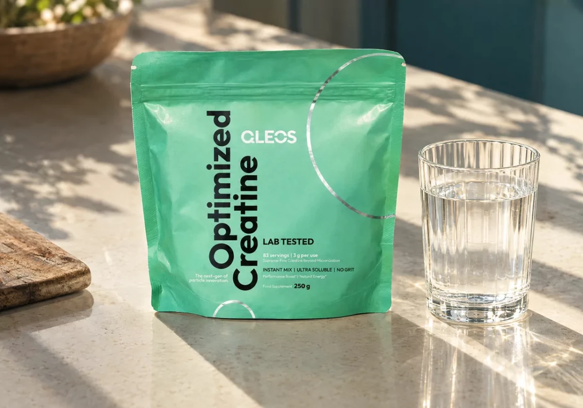 QLEOS LAB TESTED Creatine pouch beside a glass of water in daylight