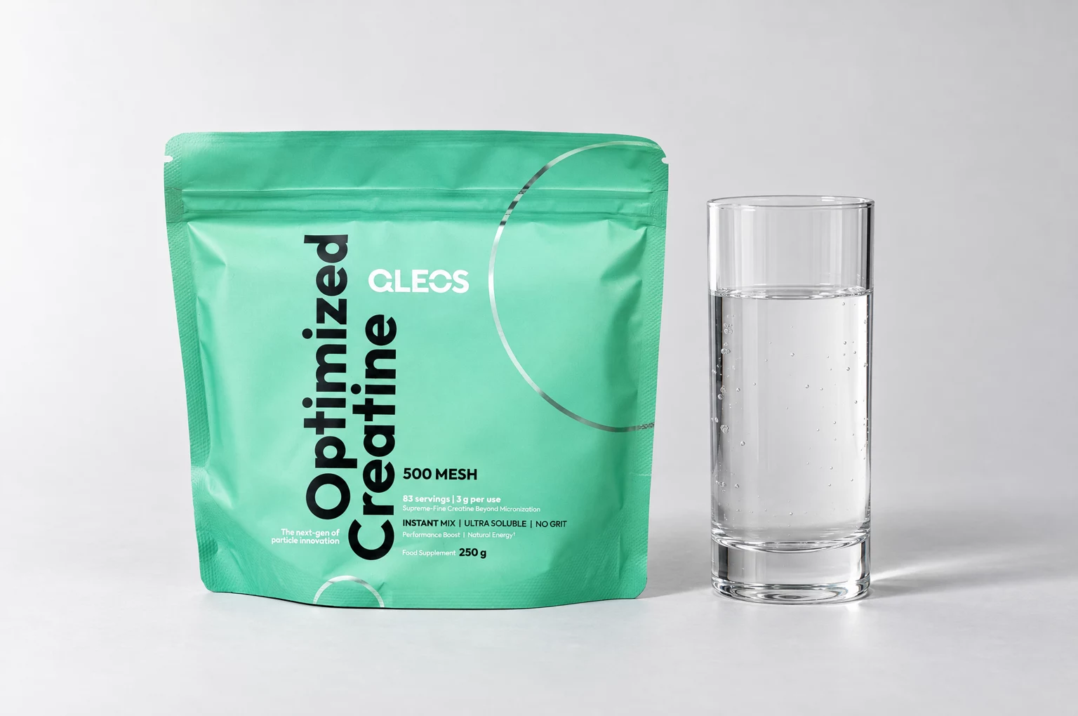 QLEOS Optimized Creatine beside a glass of clear water.