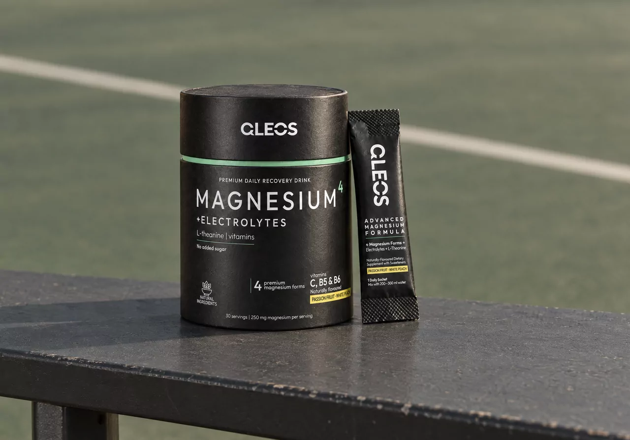 QLEOS Magnesium4 + Electrolytes tube and sachet on a courtside bench.